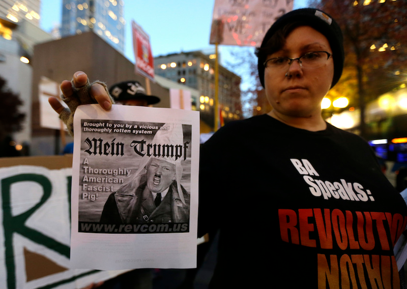 A protestor in Seattle holds an image of President-elect Donald Trump in all his glory. (Photo via AP)